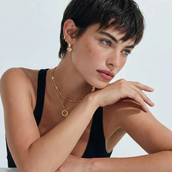 Twisted Harmony 18K Gold-Plated necklace with a fine gold-tone chain and small interlocking ring pendant