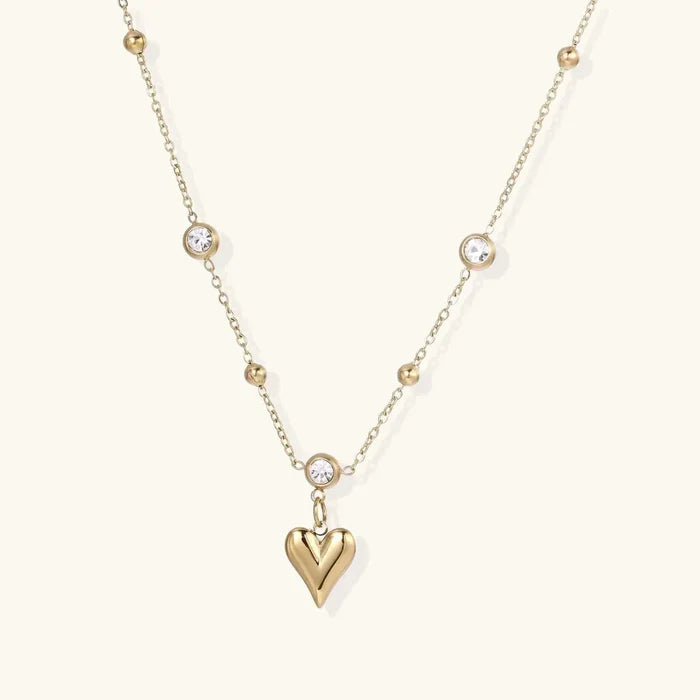 Crystal Heart Charm Necklace in gold-tone metal with a polished puffed heart pendant and clear crystals on a delicate beaded chain