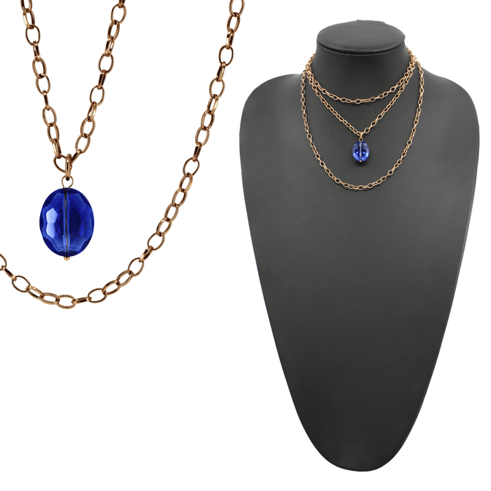 Two chain necklaces, one with a silver finish and the other with an antique gold finish, each featuring a large faceted royal blue crystal.
