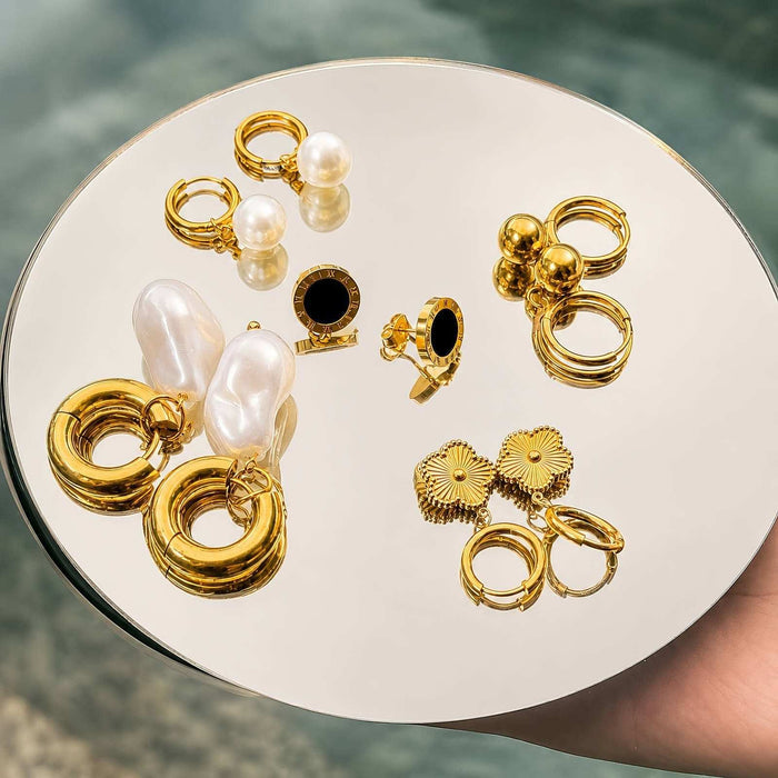 Gold Steel Stud Earrings in polished gold-tone steel, shown in several chunky hoop and stud designs with pearl accents