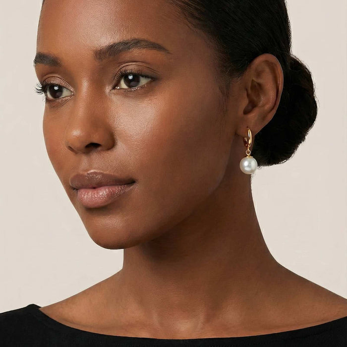 Gold Steel Stud Earrings with a gold-tone hoop setting and dangling white pearl, featuring a polished finish.