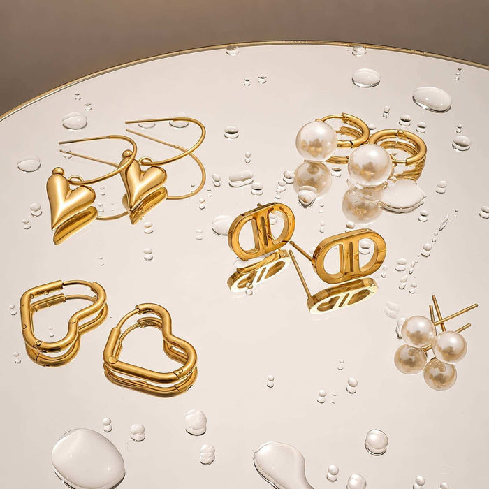 Heart Stud Earrings in glossy gold-tone metal, shown in heart and geometric shapes with pearl accents and hoop details