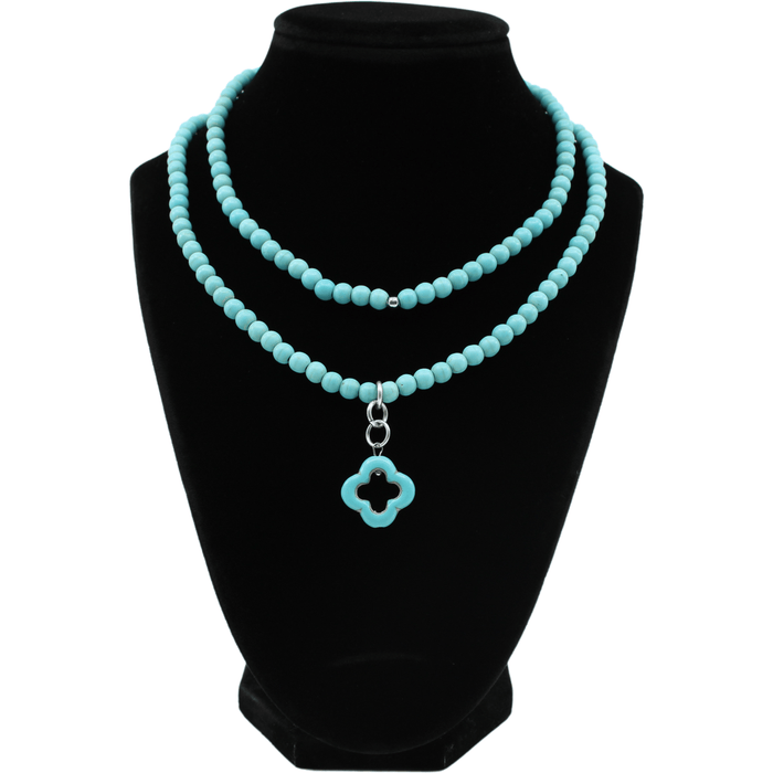 multiple colorful beaded boho wrap bracelets in 4 bright colors made with howlite beads. this image shows the turquoise blue one on a black bust worn as a necklace