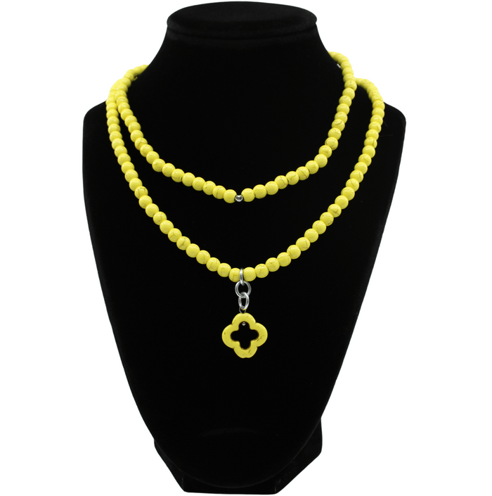 multiple colorful beaded boho wrap bracelets in 4 bright colors made with howlite beads. this image shows the yellow one on a black bust worn as a necklace