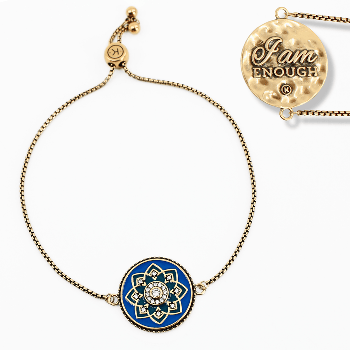 Gold bracelet with blue mandala charm and 'I am enough' pendant on a white background