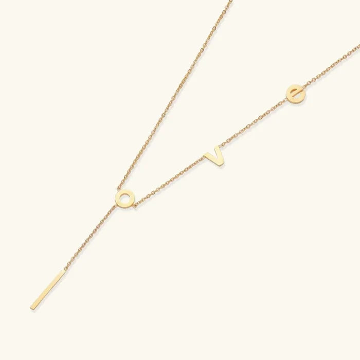 Love Letter Lariat Necklace in gold-tone metal with a delicate chain, letter details, and slim bar pendant