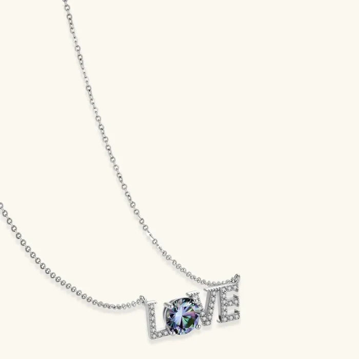 LOVE Moissanite Necklace in silver with pavé letter details and a round blue-violet center stone on a fine chain