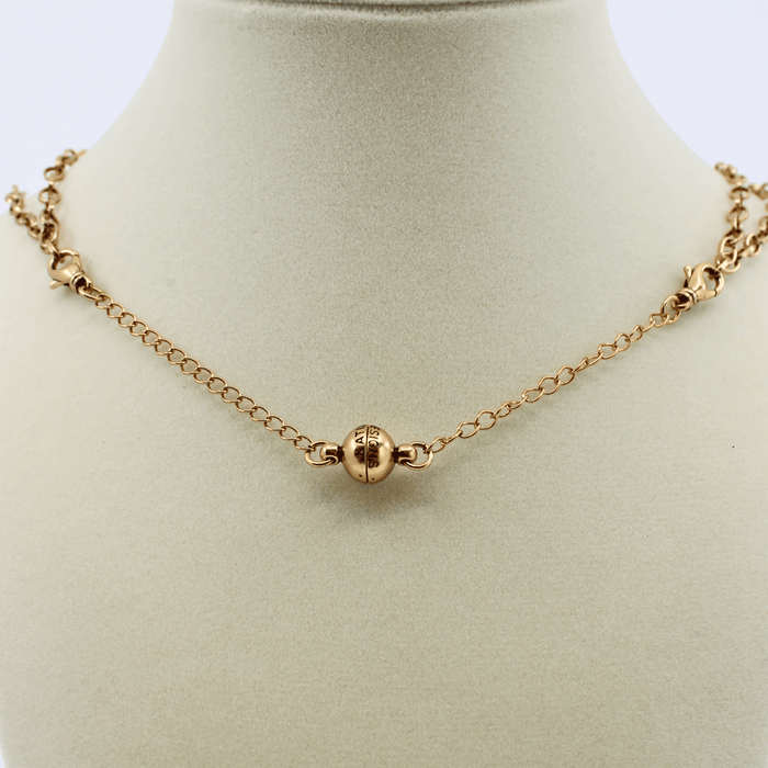 Gold necklace on a mannequin bust with a plain background