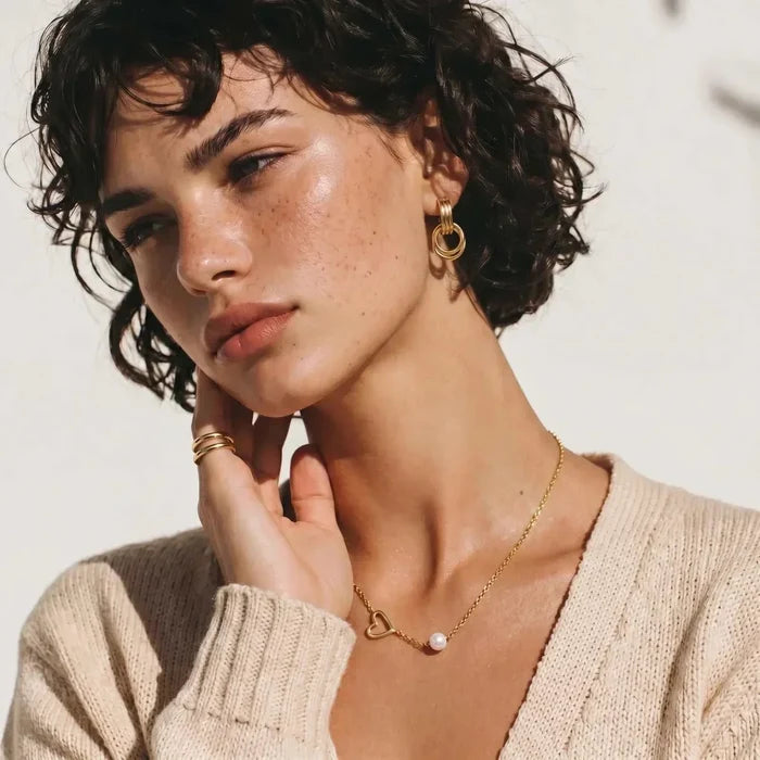 Pearl Heart Embrace Necklace with a fine gold-tone chain and open heart pendant accented by a single white pearl