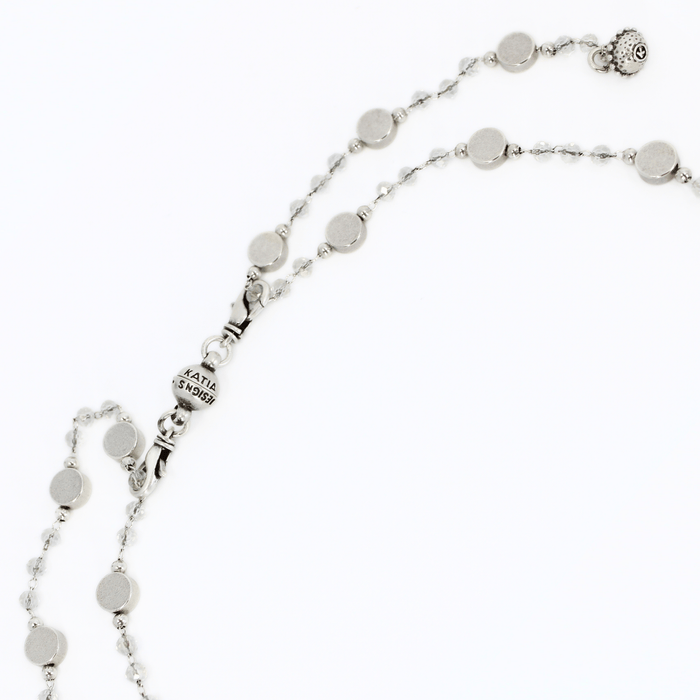 Silver necklace with round beads on a white background showing how to put on the clasp