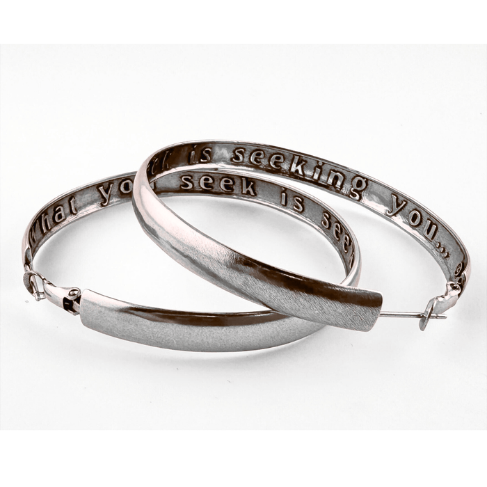 Silver hoop earrings with engraved text on a white background