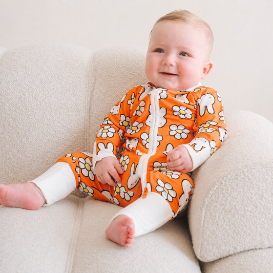 Baby wearing the ZIPSTER x Miffy Daisy Days bamboo babygrow
